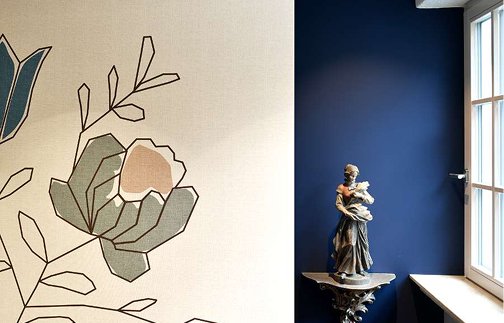 Eine blaue Wand, geschmückt mit einem Design aus Blumen.