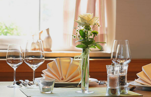 Eine Vase mit Blumen steht auf einem Tisch und verleiht dem Raum Farbe und Leben.